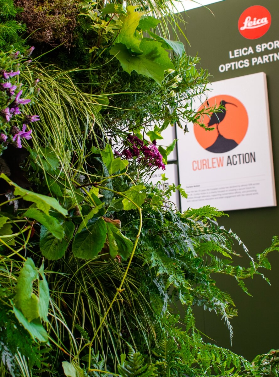 Close-up detail of a bespoke Leica exhibition stand featuring premium branded graphics and living wall for an immersive spatial design experience.